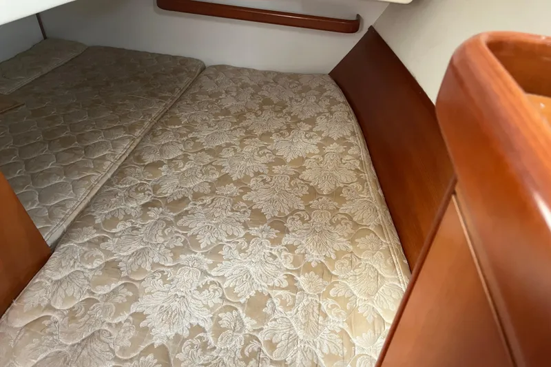 Slide: The Image of Interior cabin of 2006 Beneteau Oceanis Clipper 373 with patterned bedding and wooden accents. - 29