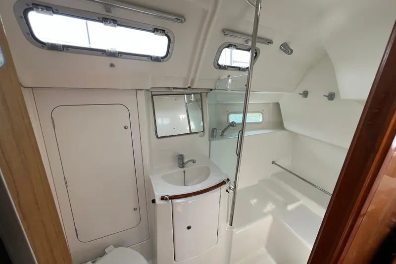 Slide: The Image of Beneteau Oceanis Clipper 373 bathroom interior, 2006 model, featuring sink, shower, and portholes. - 18