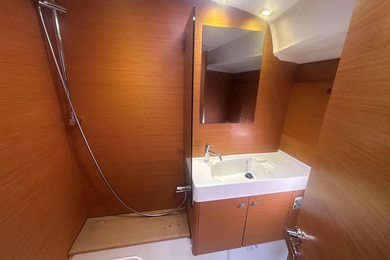 Slide: The Image of Bathroom interior of 2014 Jeanneau Sun Odyssey 509 yacht, featuring wooden cabinetry and modern fixtures. - 33