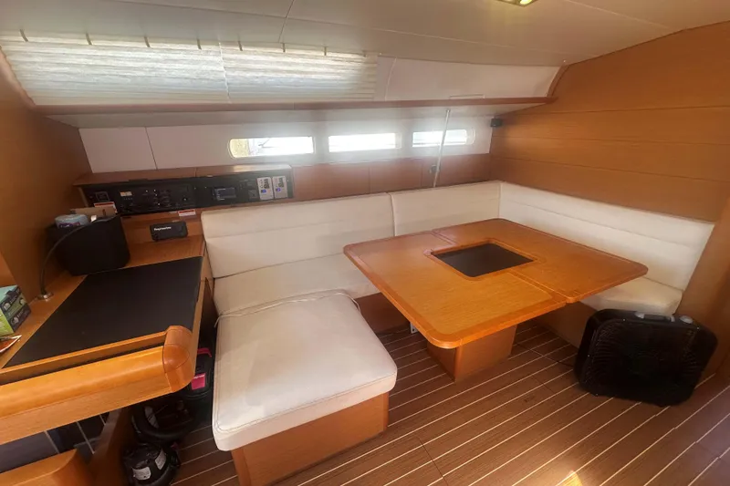 Slide: The Image of Interior of 2014 Jeanneau Sun Odyssey 509 yacht with wooden table and white seating. - 21