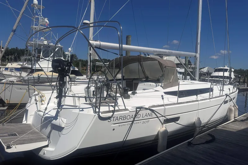 Slide: The Image of 2014 Jeanneau Sun Odyssey 509 sailboat docked at marina under clear blue sky. - 2