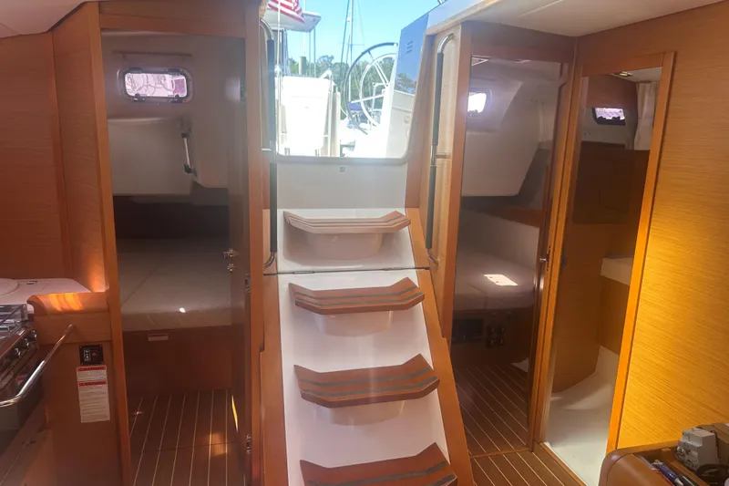 Slide: The Image of Interior view of 2014 Jeanneau Sun Odyssey 509 yacht with wooden finish and cabin access. - 17