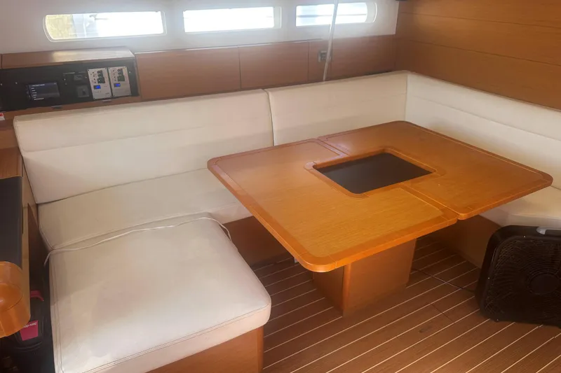 Slide: The Image of Interior of 2014 Jeanneau Sun Odyssey 509 yacht with wooden table and white seating. - 22