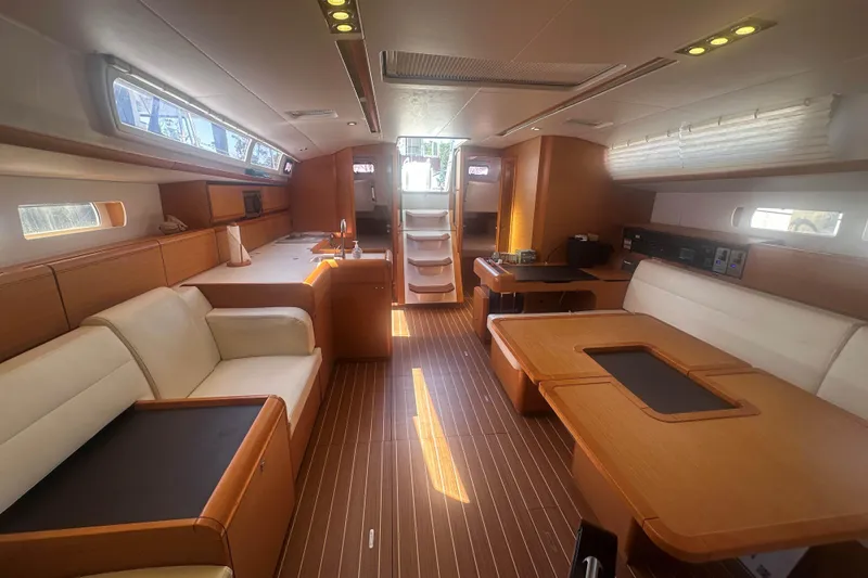 Slide: The Image of Interior of 2014 Jeanneau Sun Odyssey 509 yacht, featuring elegant wood finishes and spacious seating. - 16