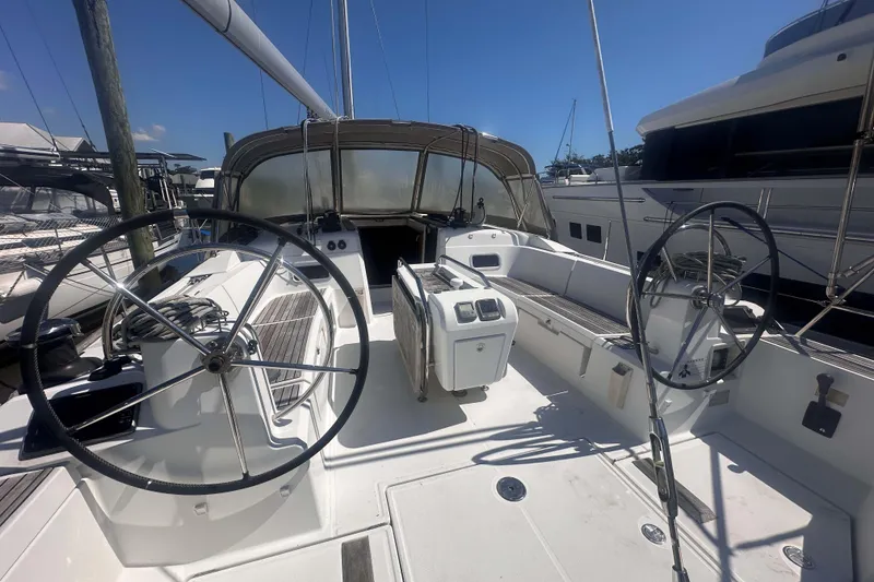 Slide: The Image of 2014 Jeanneau Sun Odyssey 509 sailboat cockpit with dual steering wheels, docked at marina. - 6