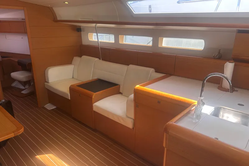 Slide: The Image of Interior of 2014 Jeanneau Sun Odyssey 509 yacht with modern wood finish and cozy seating. - 24