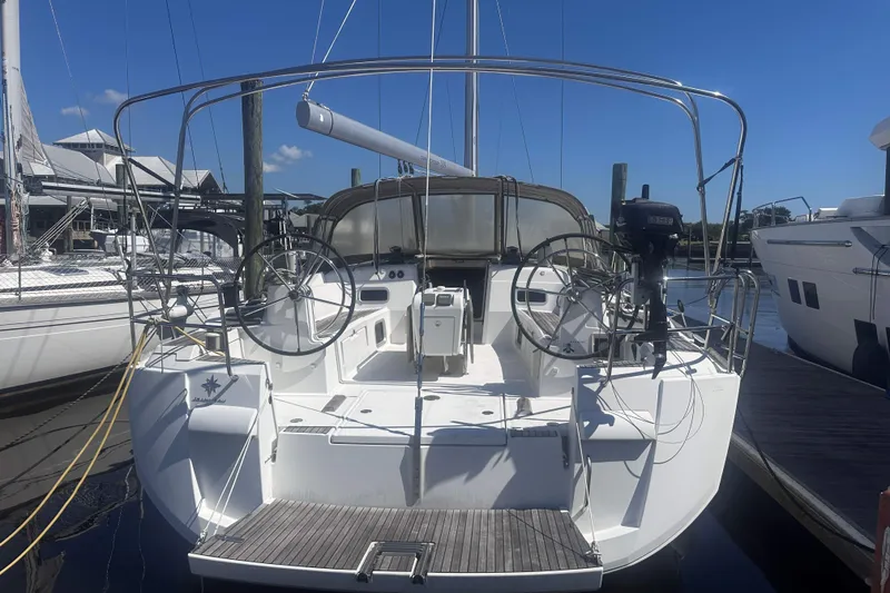 Slide: The Image of 2014 Jeanneau Sun Odyssey 509 sailboat docked, showcasing dual steering wheels and spacious cockpit. - 3
