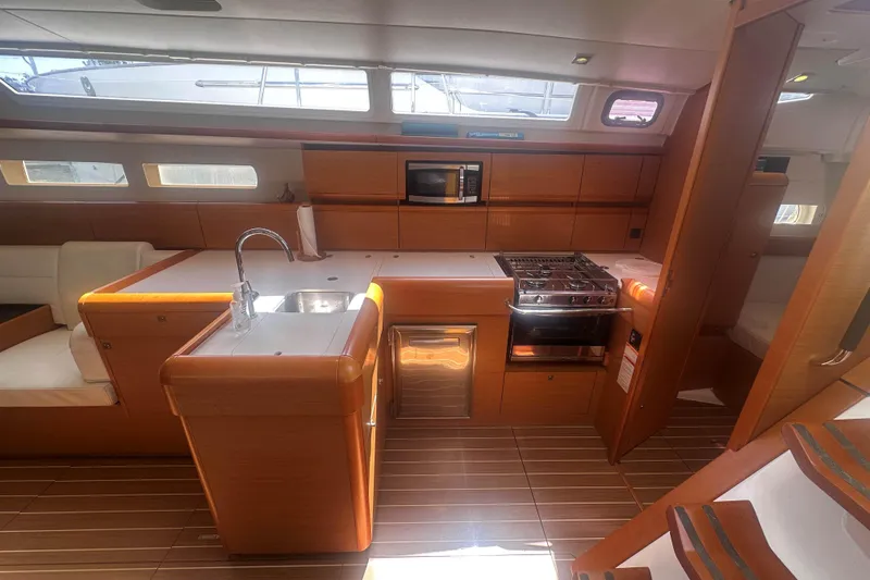Slide: The Image of Interior of 2014 Jeanneau Sun Odyssey 509 yacht, featuring modern kitchen and seating area. - 25