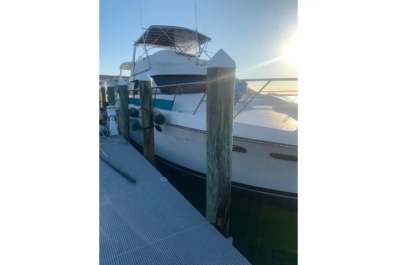 Slide: The Image of 1989 Silverton 46 Aft Cabin yacht docked at sunset, showcasing sleek design and spacious deck. - 4