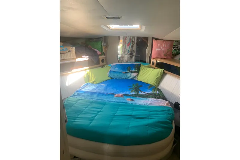 Slide: The Image of Cozy bedroom in 1989 Silverton 46 Aft Cabin with tropical-themed bedding and decorative pillows. - 10