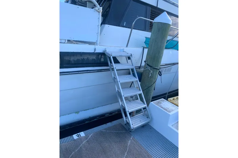 Slide: The Image of Stairs leading to a 1989 Silverton 46 Aft Cabin yacht docked at a marina. - 6