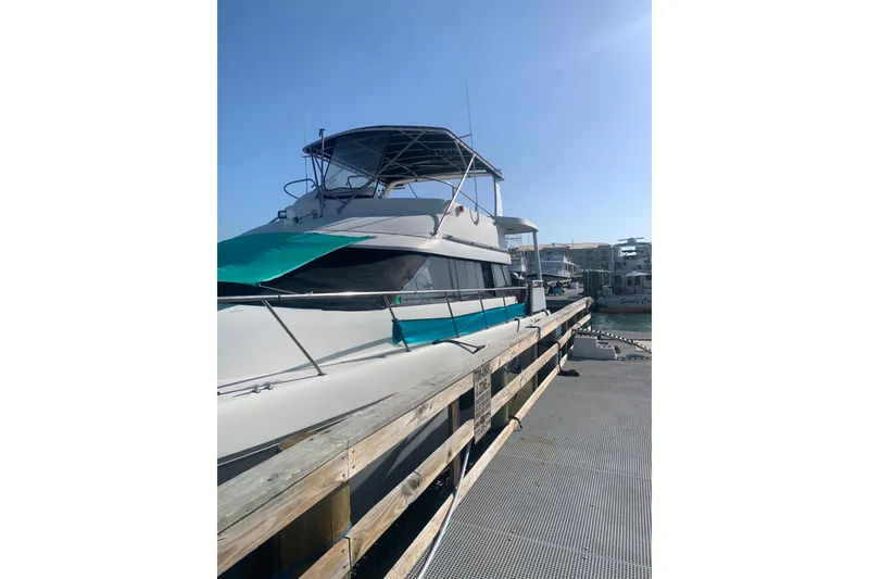 Slide: The Image of 1989 Silverton 46 Aft Cabin yacht docked under clear blue sky. - 5