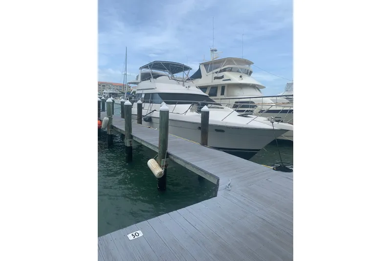 Slide: The Image of 1989 Silverton 46 Aft Cabin yacht docked at marina under clear sky. - 3