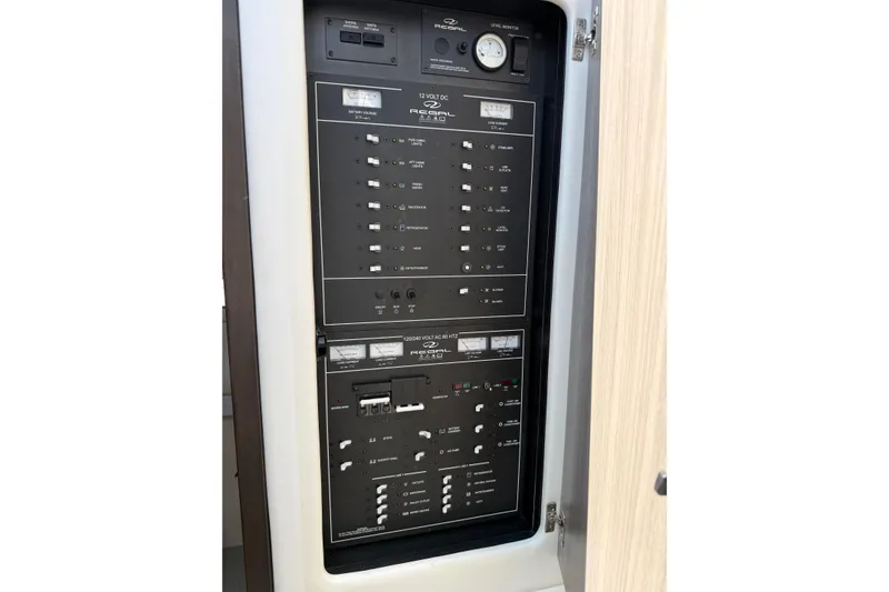 Slide: The Image of Electrical control panel inside 2020 Regal 38 Grande Coupe yacht, showcasing switches and gauges. - 26