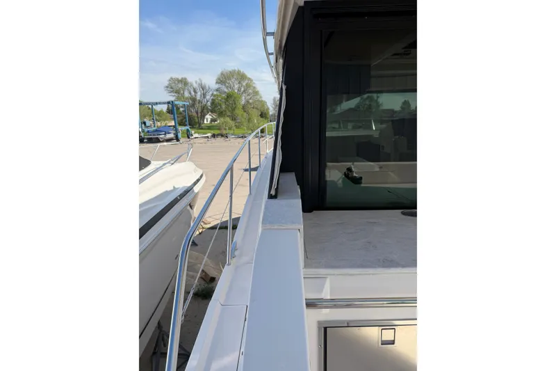 Slide: The Image of 2020 Regal 38 Grande Coupe yacht side view with railing and docked setting. - 11