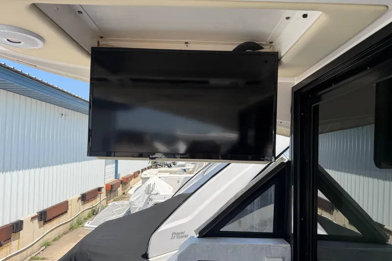 Slide: The Image of Flat-screen TV on 2020 Regal 38 Grande Coupe yacht, docked near a warehouse. - 9