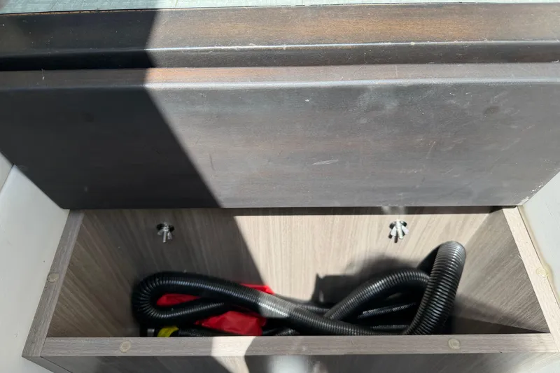 Slide: The Image of Storage compartment in 2020 Regal 38 Grande Coupe with coiled hose and red fabric. - 28