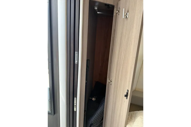 Slide: The Image of Open wooden cabinet door inside 2020 Regal 38 Grande Coupe yacht interior. - 34
