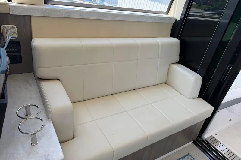 Slide: The Image of Luxurious interior seating on a 2020 Regal 38 Grande Coupe yacht, featuring cream upholstery. - 21