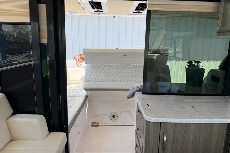Slide: The Image of Interior view of a 2020 Regal 38 Grande Coupe yacht, featuring seating and cabinetry. - 12