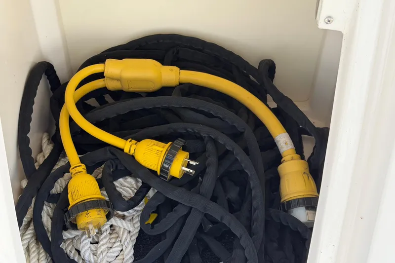 Slide: The Image of Yellow power cables and ropes stored in a compartment of a 2020 Regal 38 Grande Coupe. - 7