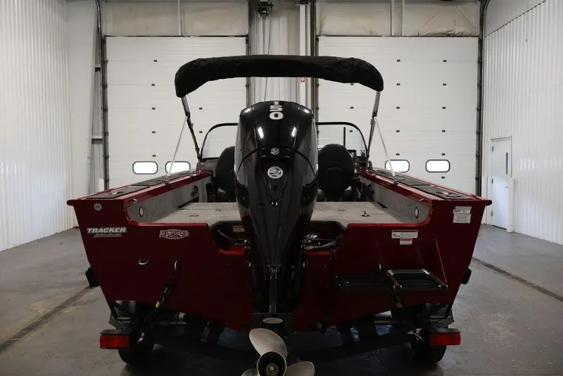 Slide: The Image of 2024 Tracker Targa V-18 Combo boat in a garage, rear view with motor. - 37