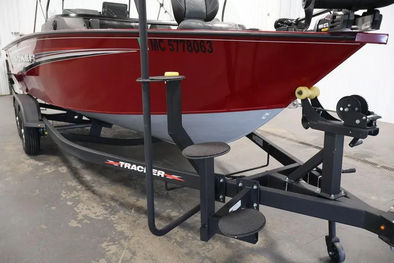 Slide: The Image of 2024 Tracker Targa V-18 Combo boat on trailer, red exterior, side view. - 59