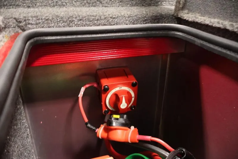 Slide: The Image of 2024 Tracker Targa V-18 Combo battery switch compartment with red wiring. - 49