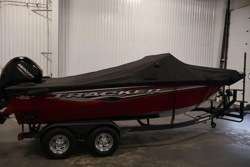 Slide: The Image of 2024 Tracker Targa V-18 Combo boat with cover, parked indoors on trailer. - 50