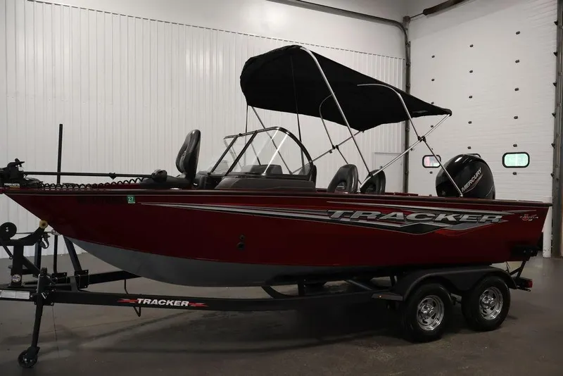 Slide: The Image of 2024 Tracker Targa V-18 Combo boat with canopy in indoor setting. - 52
