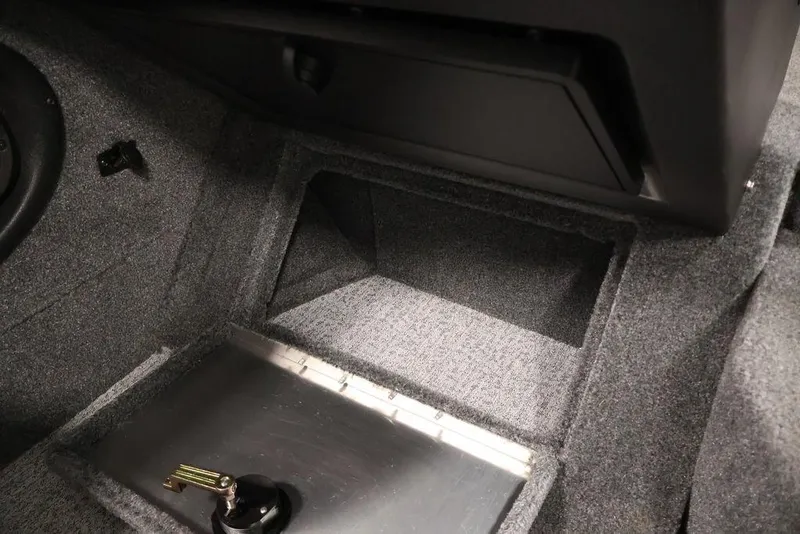 Slide: The Image of 2024 Tracker Targa V-18 Combo interior storage compartment with carpeted finish and secure latch. - 16