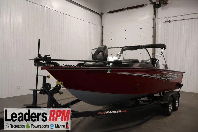Slide: The Image of 2024 Tracker Targa V-18 Combo boat in showroom, red exterior, on trailer. - 33