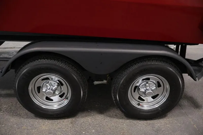 Slide: The Image of 2024 Tracker Targa V-18 Combo trailer wheels with chrome rims and black tires. - 60
