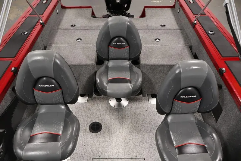 Slide: The Image of 2024 Tracker Targa V-18 Combo boat interior with three gray seats and red accents. - 14
