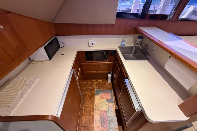 Slide: The Image of 1989 Viking 35 Convertible yacht kitchen with wood cabinetry, sink, and appliances. - 28