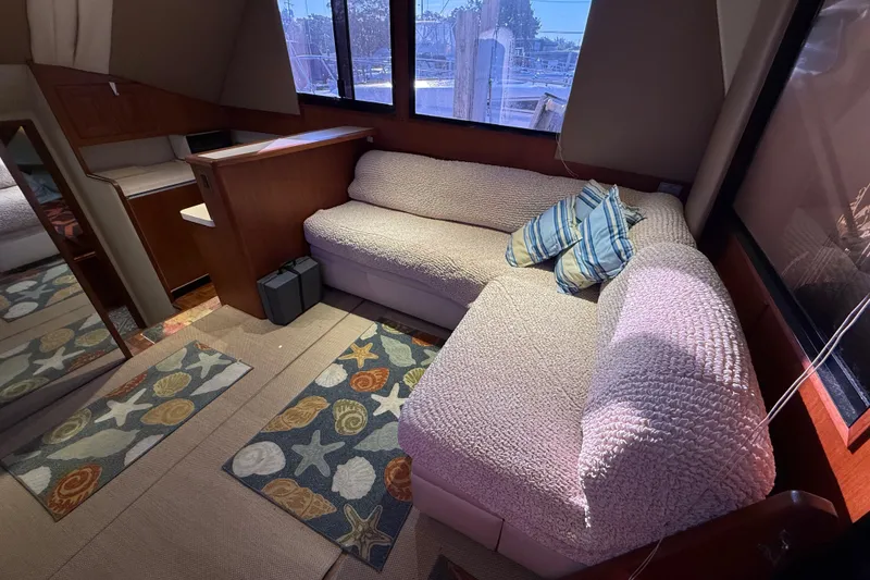Slide: The Image of Cozy interior of 1989 Viking 35 Convertible yacht with plush seating and nautical-themed decor. - 21