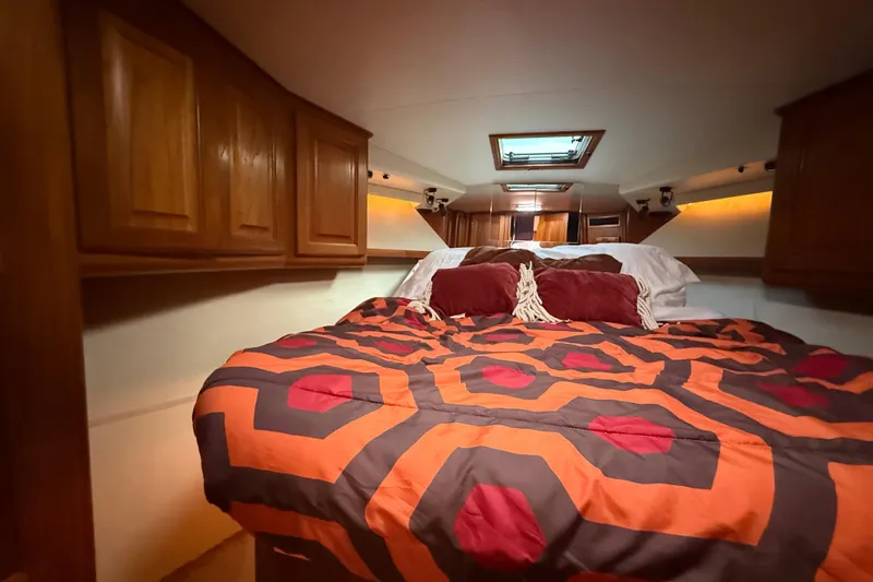 Slide: The Image of Cozy cabin interior of 1989 Viking 35 Convertible with vibrant bedding and wooden cabinets. - 32