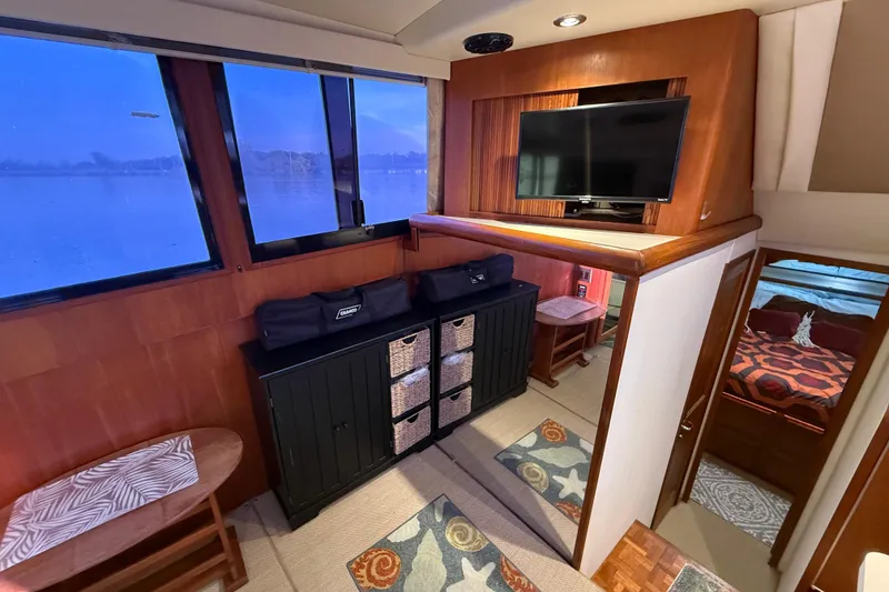 Slide: The Image of Interior of 1989 Viking 35 Convertible yacht with cozy furnishings and a mounted TV. - 25