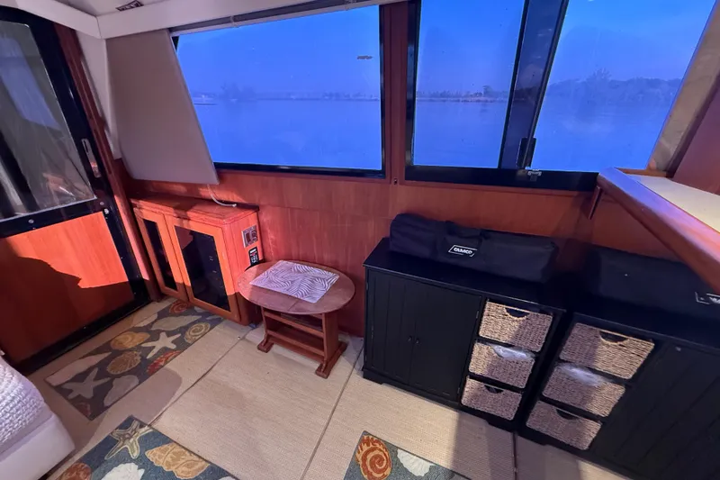Slide: The Image of Interior of 1989 Viking 35 Convertible boat with wooden cabinets and decorative rugs. - 24