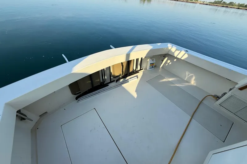 Slide: The Image of 1989 Viking 35 Convertible boat deck with storage compartments, docked on calm water. - 12
