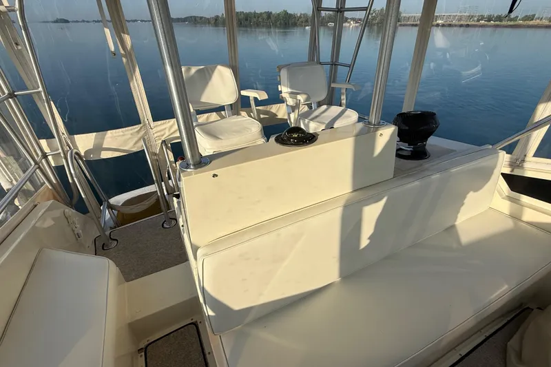 Slide: The Image of 1989 Viking 35 Convertible boat interior with seating and helm, overlooking calm waters. - 16
