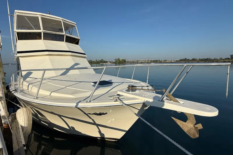 Slide: The Image of 1989 Viking 35 Convertible boat docked on calm water under clear blue sky. - 3