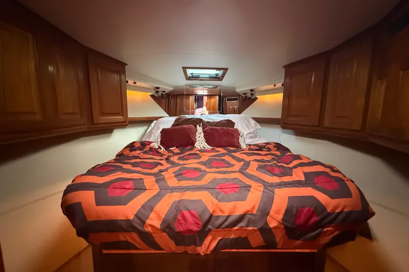 Slide: The Image of Cozy cabin interior of 1989 Viking 35 Convertible with vibrant bedding and wooden cabinets. - 30