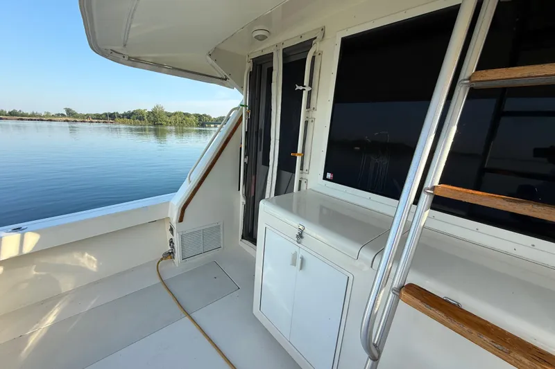 Slide: The Image of 1989 Viking 35 Convertible boat deck with ladder and serene water view. - 14