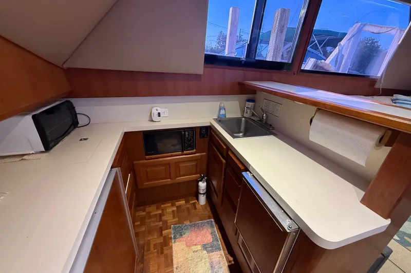 Slide: The Image of 1989 Viking 35 Convertible yacht kitchen with sink, microwave, and wooden cabinetry. - 29