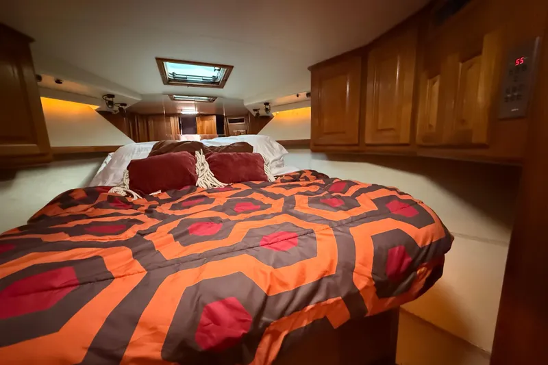 Slide: The Image of Cozy cabin interior of 1989 Viking 35 Convertible with vibrant bedding and wooden cabinetry. - 31