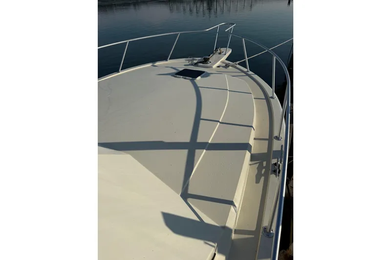 Slide: The Image of 1989 Viking 35 Convertible boat deck with railing, docked on calm water. - 6