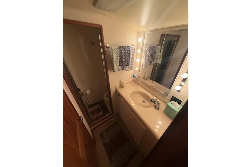 Slide: The Image of Bathroom interior of 1989 Viking 35 Convertible yacht, featuring sink, mirror, and shower. - 33