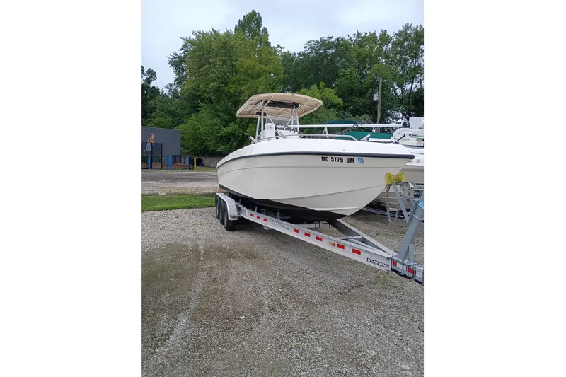 Slide: The Image of 2002 Paramount Supper Fish boat on trailer, parked outdoors with trees in background. - 1