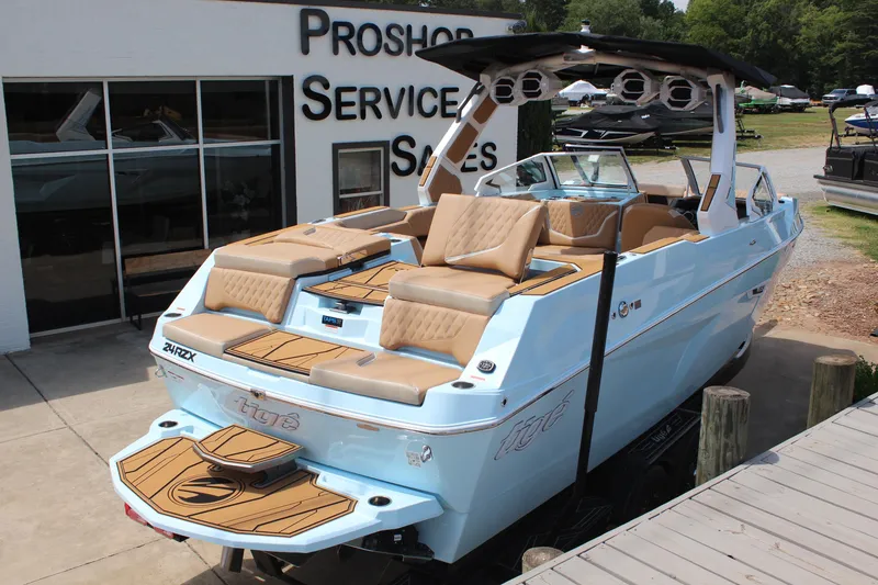 Slide: The Image of 2026 Tigé 24RZX boat with sleek design, displayed at a dealership. - 5